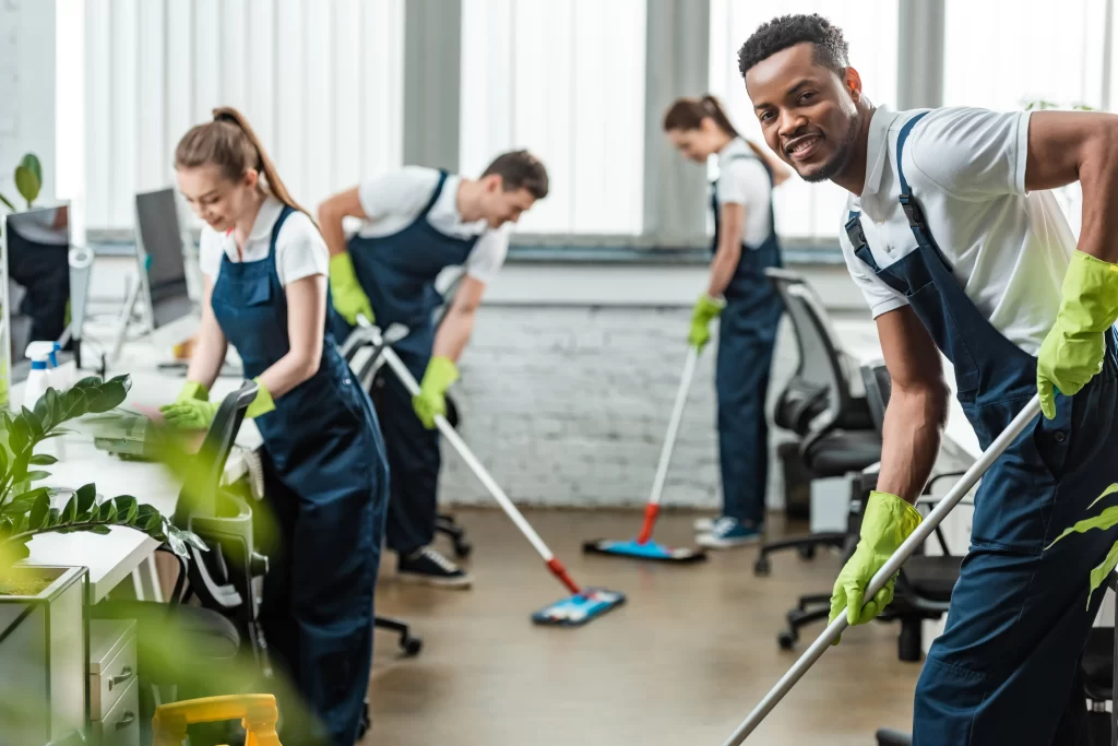 Workers smiling while cleaning the office.