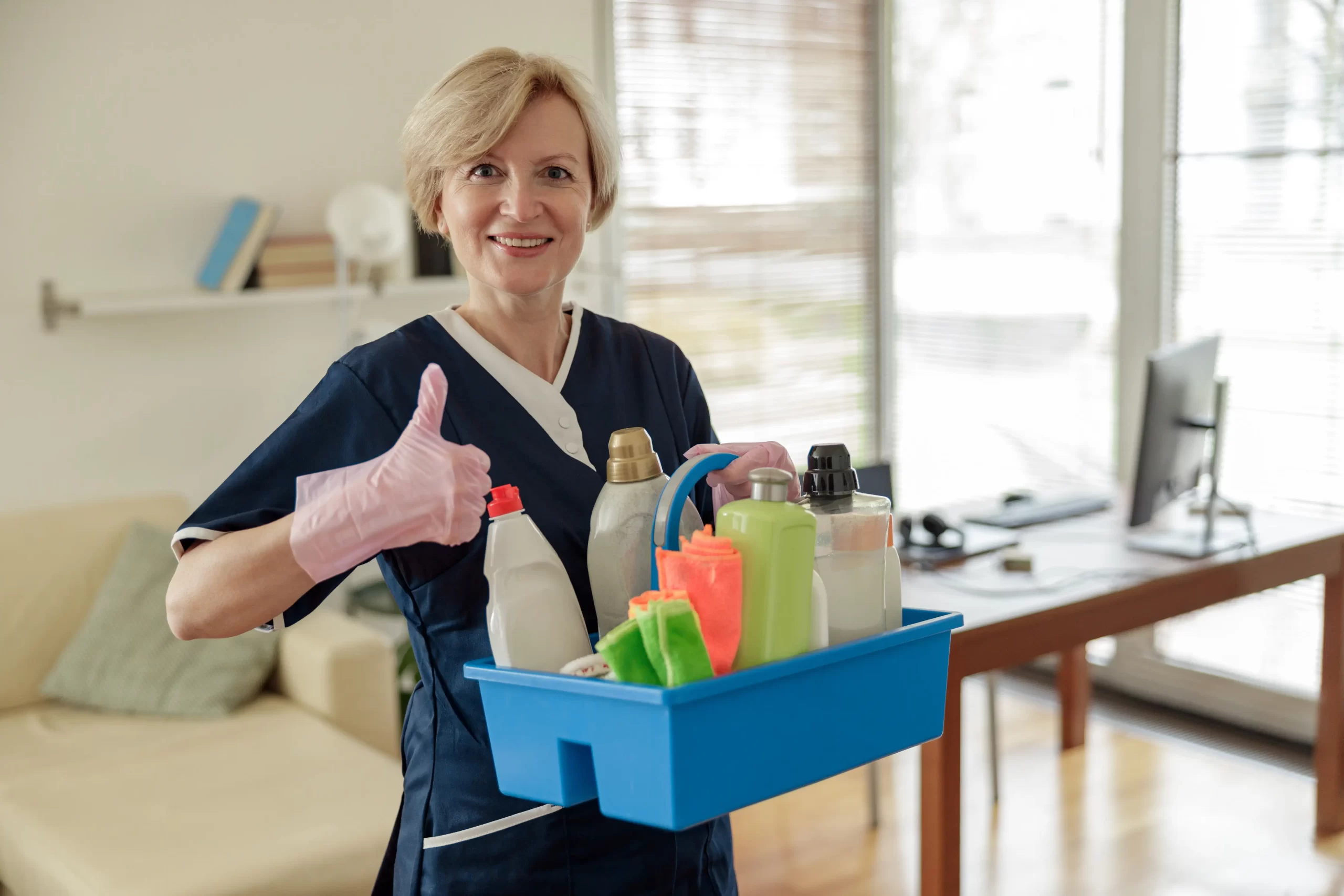 A cleaning lady giving a thumbs up while holding a cleaning tools.
